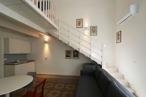 Ein kompakter Wohnraum mit Treppe, Essbereich und Sofa.