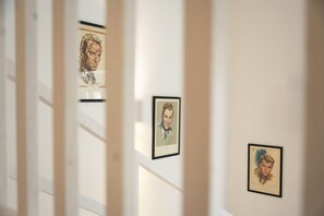 Ein Flur mit gerahmten Kunstwerken an den Wänden.
