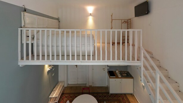 Una stanza piccola e funzionale con un letto a castello, un angolo cottura e un bagno.