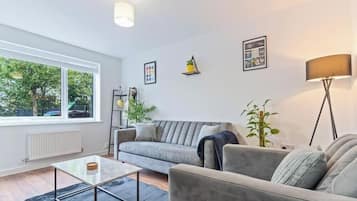 A modern living room with a sofa, a coffee table, and a floor lamp.