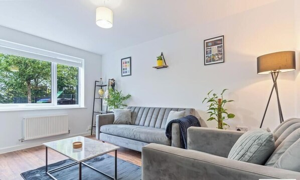 Una sala de estar moderna con un sofá, una mesa de centro y una lámpara de pie.