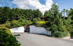 A secluded cabin surrounded by dense forest, with a white exterior and a sloped roof. - Spacious Group Accommodation in Saalfelden (Saalfelden am Steinernen Meer)