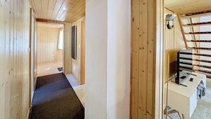 Ein Holzeinrichtung mit einem Flur, der zu einem Zimmer mit einem Bett und einem Schreibtisch führt.
