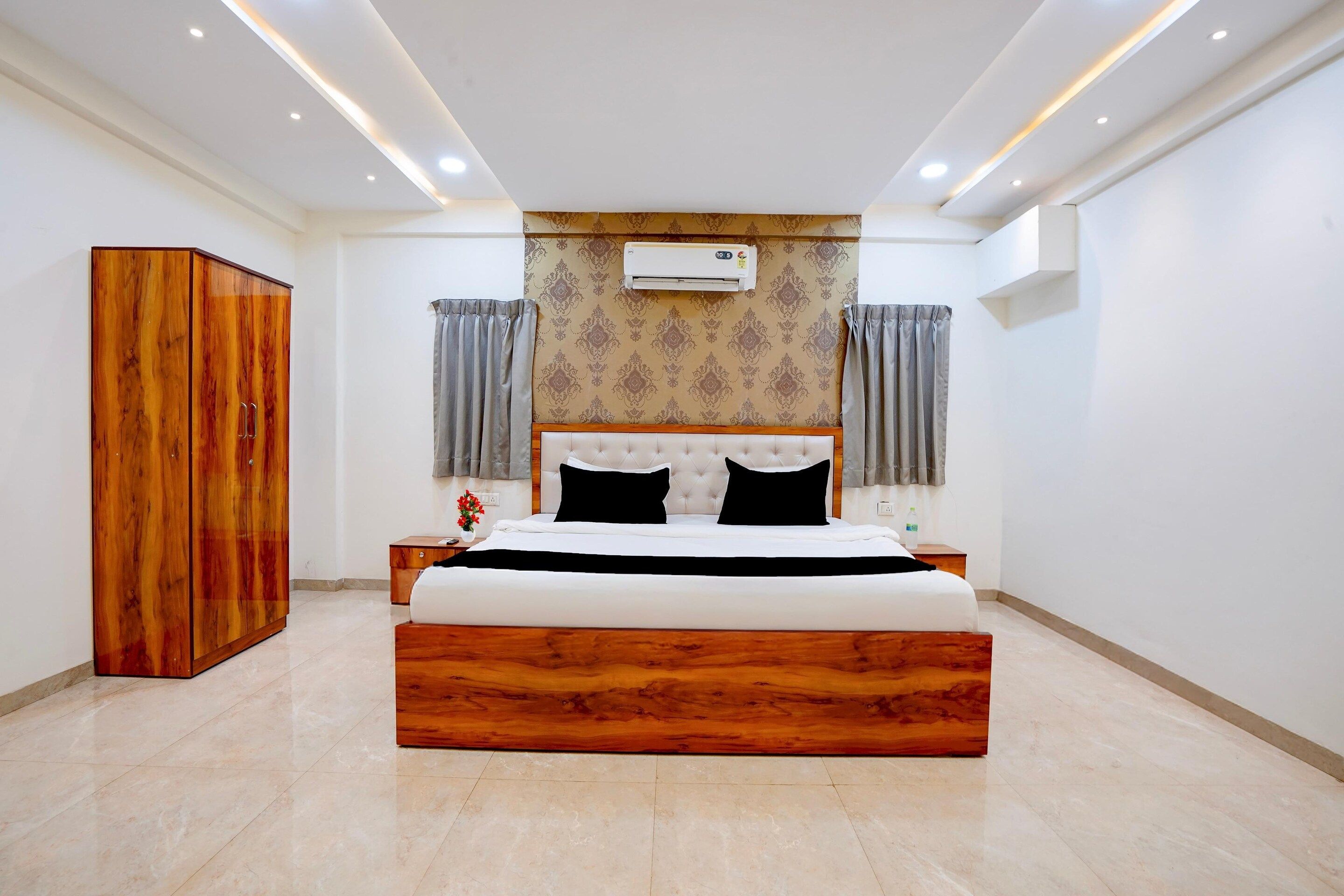 Un dormitorio con una cama grande, un armario de madera y un equipo de aire acondicionado en la pared.