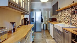 A modern kitchen with a stainless steel refrigerator, a coffee maker, and a toaster. - La Maison des Prés - Maison bourgeoise de 1890 (Montceau-les-Mines)