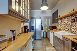 A modern kitchen with a stainless steel refrigerator, a coffee maker, and a toaster. - La Maison des Prés - Maison bourgeoise de 1890 (Montceau-les-Mines)