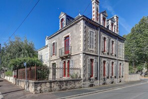 A two-story building with a symmetrical facade, multiple windows with shutters, and a central entrance. - La Maison des Prés - Maison bourgeoise de 1890 (Montceau-les-Mines)