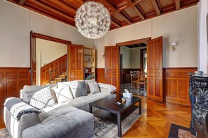 Un soggiorno con divano, tavolino da caffè e un lampadario decorativo.