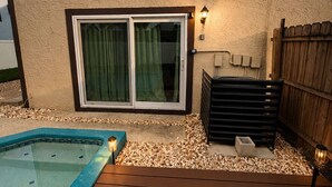 Ein Garten mit Schwimmbad, Holzterrasse und überdachter Terrasse.