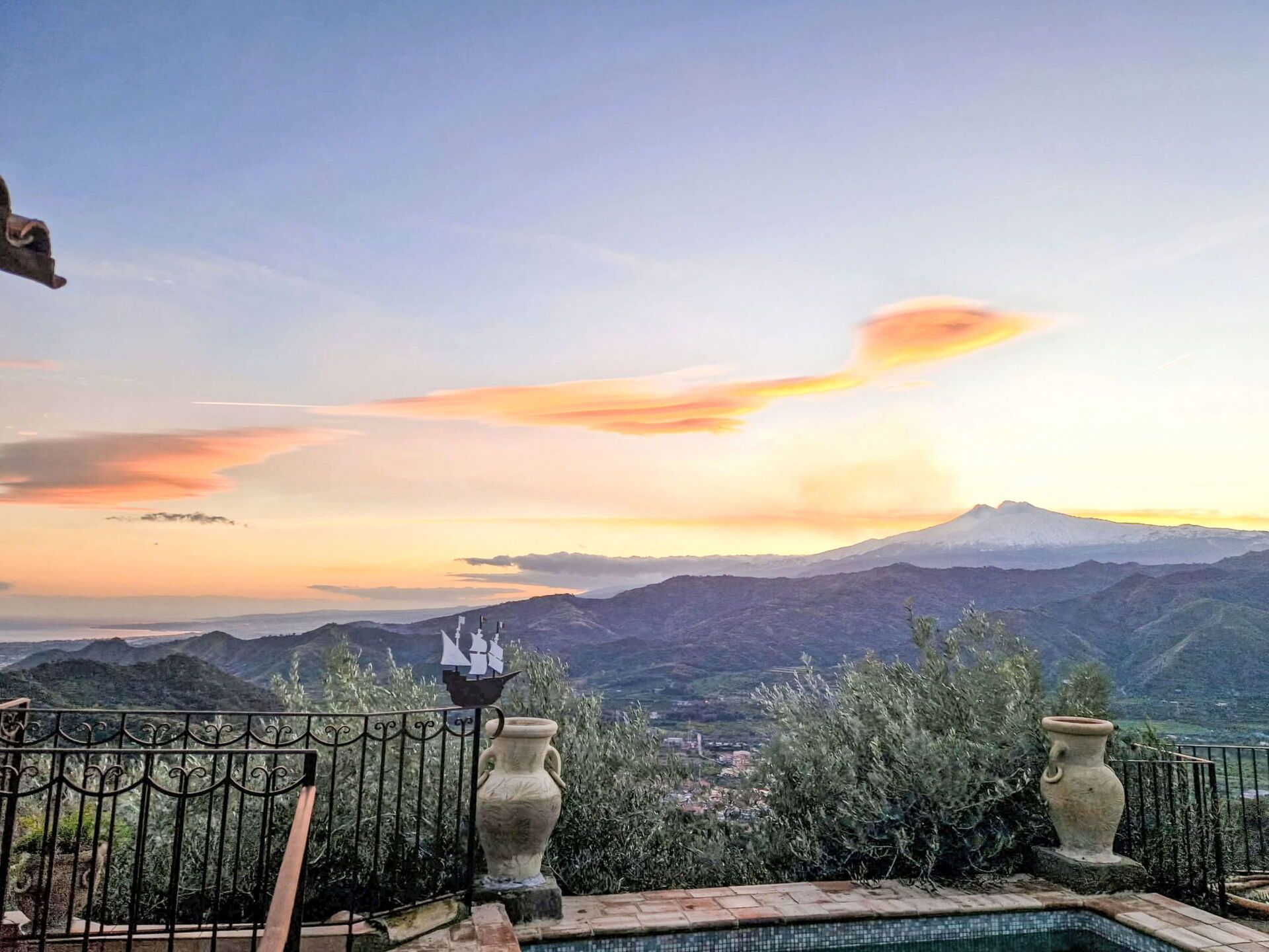A pool with a view of mountains and a sunset.