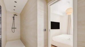 Un bagno moderno con doccia, un water e un letto con materasso bianco.