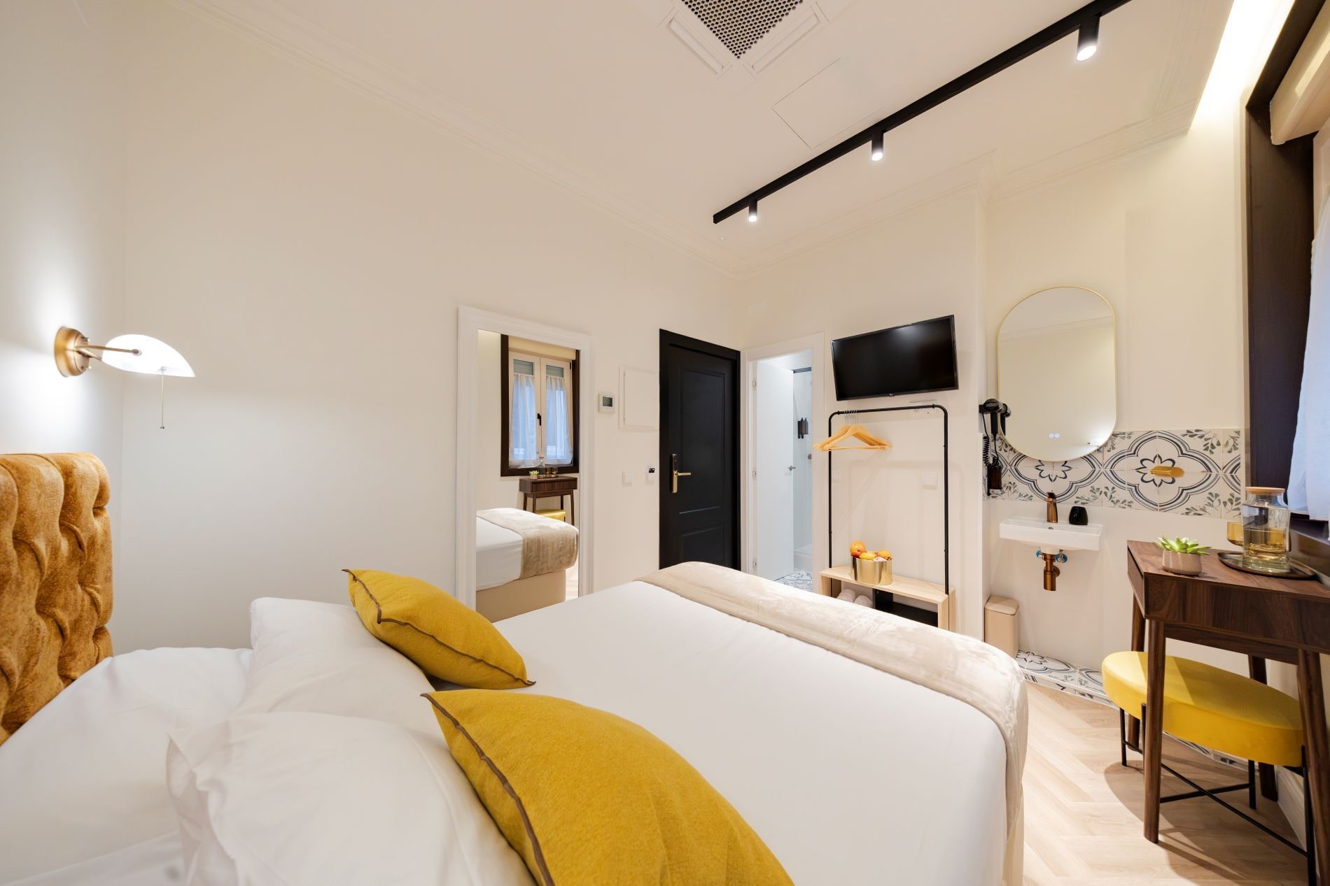 Habitació d'hotel amb un llit, escriptori, mirall i televisió.