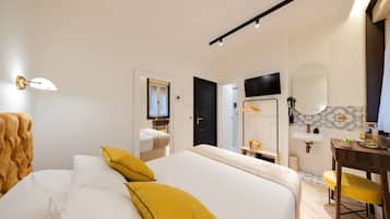Habitació d'hotel amb un llit, escriptori, mirall i televisió.