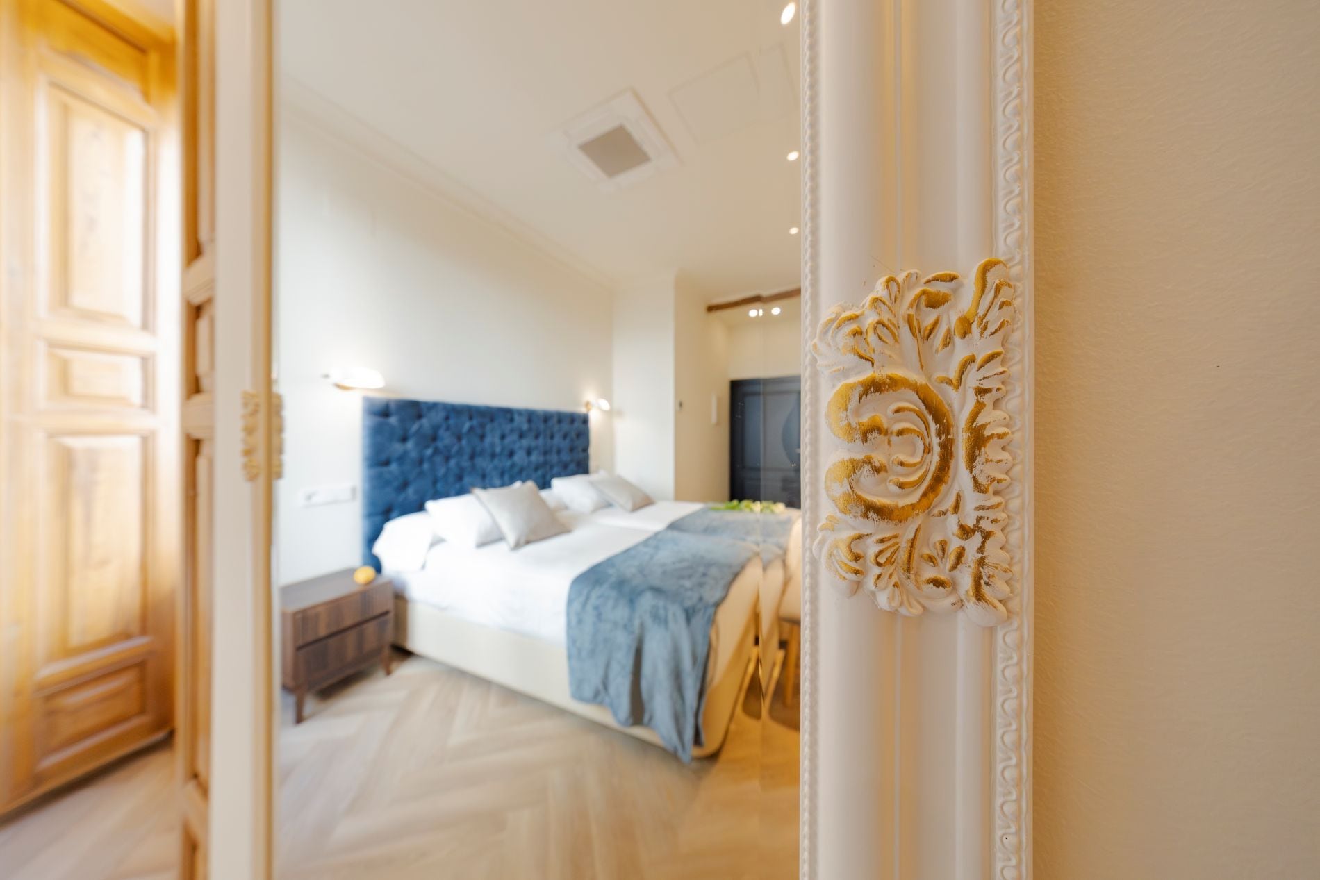 A bedroom with a large bed, a nightstand, and a dresser.