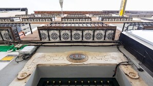 Una terrazza sul tetto con ringhiere metalliche e un elemento decorativo centrale con il numero 28.