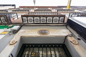Una terraza en la azotea con una serie de barandillas metálicas y un elemento decorativo central con el número 28.