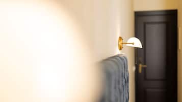 A bathroom with a towel rack, a door, and a wall-mounted light fixture.