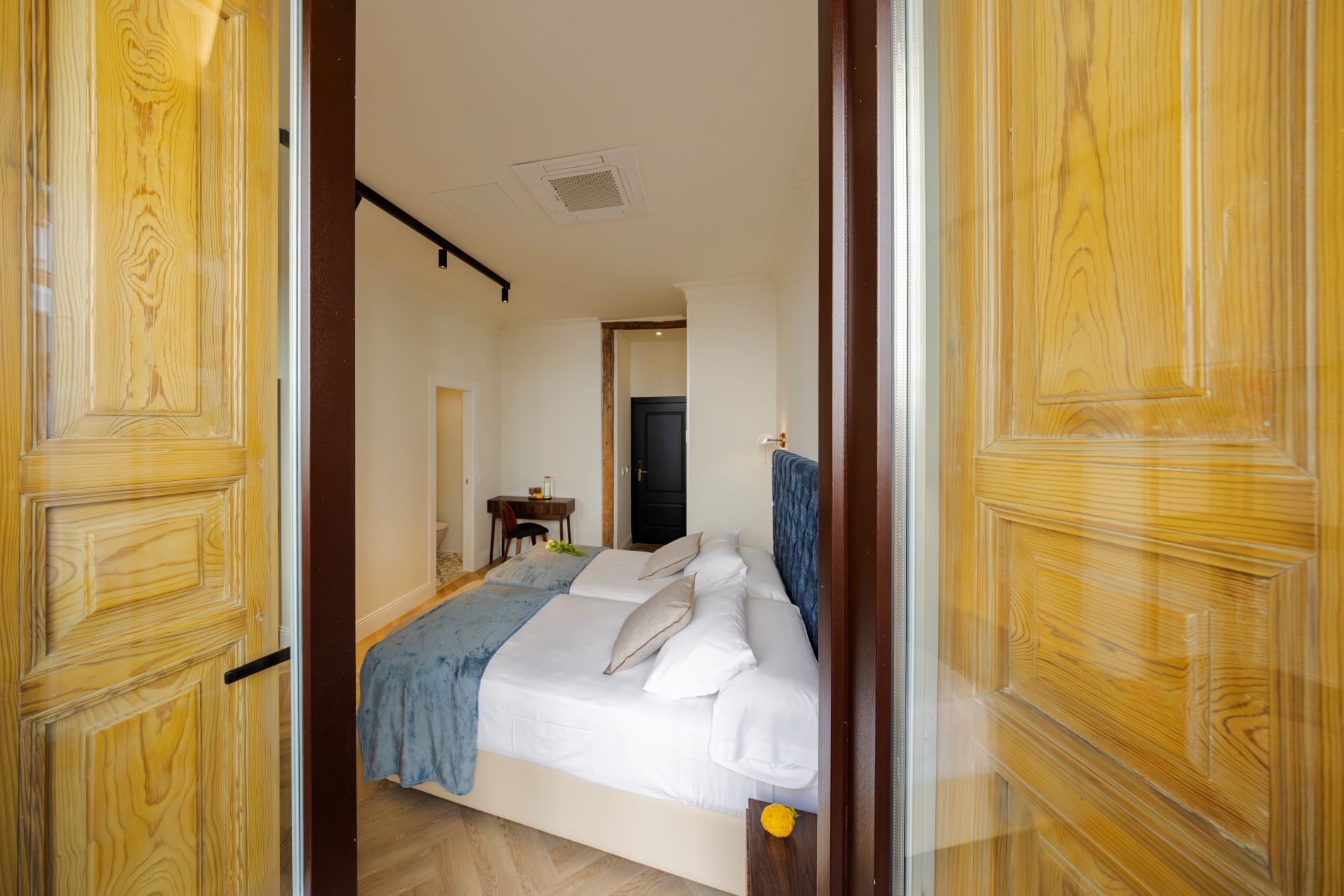Quarto de hotel com cama, escrivaninha e cadeira.