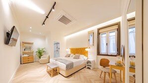 Una camera da letto moderna con un letto, un comodino, una sedia e una scrivania con altra sedia.