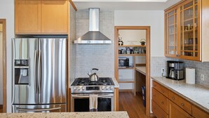 A modern kitchen with stainless steel appliances, a gas stove, and wooden cabinets.