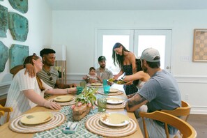 A group of people seated around a table with a floral centerpiece, engaged in conversation. - Livin' La Vida Lakehouse (Henrico)