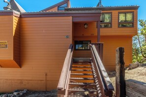 Ein Holzhaus mit einer Treppe, die zu einem Eingang führt.