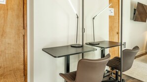 Ein Zimmer mit zwei Schreibtischen, zwei Stühlen und zwei Stehlampen.