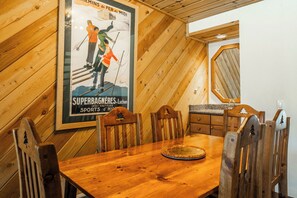 A wooden dining table with chairs, a poster on the wall, and a wooden ceiling. - Beautiful updated Courchevel by the Slopes. Sleeps up to 8 guests! (Mammoth Lakes)