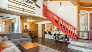 Ein großzügiger Wohnbereich mit moderner Treppe, Holzböden und einer gemütlichen Sitzecke.