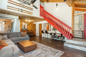 Ein großzügiger Wohnbereich mit moderner Treppe, Holzböden und einer gemütlichen Sitzecke.