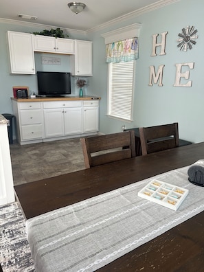 A dining area with a wooden table, chairs, and a decorative tray. - Cozy 1-bedroom tiny home in resort setting (Citra)