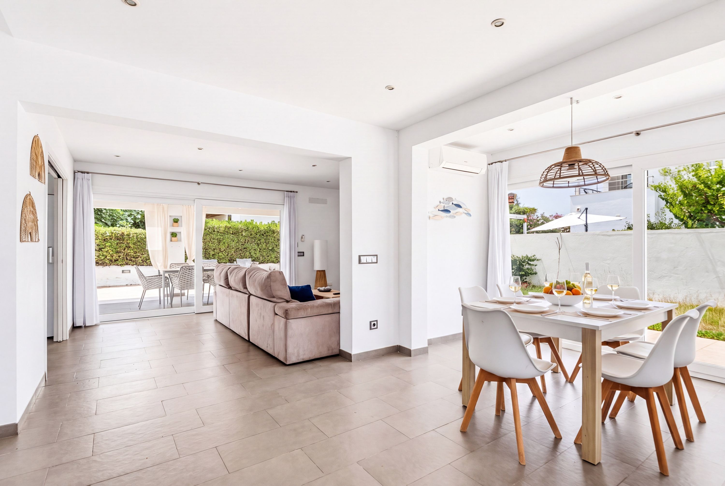 Un interior moderno con comedor, sofá y vistas al exterior.