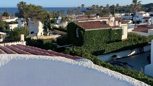 Eine Küstenwohngegend mit weißen Gebäuden, blauem Himmel und Blick auf das Meer.