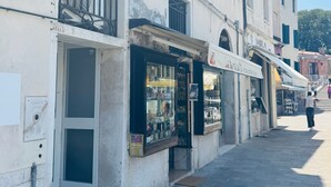 Un edificio con un cartello che indica 'Hotel Airone' e un negozio chiamato 'Mira'.