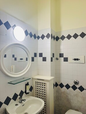 A bathroom with a white sink, a round mirror, and a toilet. - Double Room 1 with Wi-Fi and Air Conditioning (Venice)