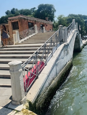 A stone bridge with metal railings and steps leading to a building. - Room 'Ca Pisani Su Canal Grande Azzuro' with Wi-Fi (Venice)