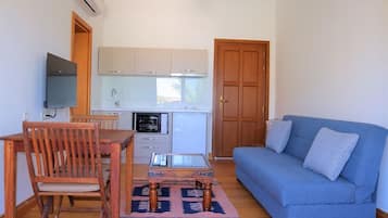Family Suite, Patio, Sea View | Living area | 32-inch LCD TV with satellite channels
