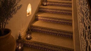 Una escalera con peldaños decorados, luces empotradas en la pared y cuadros enmarcados.