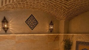 A traditional bath area with a marble floor, a bench, and a shelf with decorative items. - riad el barodienne  (Marrakech)