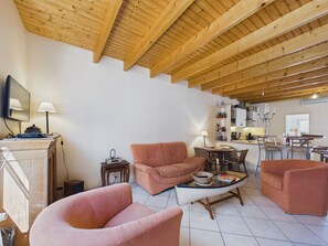 A spacious living area with a high wooden ceiling, a television on a stand, and a kitchen in the background. - 350 m from the Main Beach - House 4 adt/ 2 chd (Les Sables-d´Olonne)