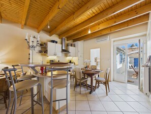 A modern kitchen with wooden beams, a bar area, and a dining space with chairs and tables. - 350 m from the Main Beach - House 4 adt/ 2 chd (Les Sables-d´Olonne)