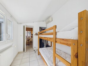 A bunk bed room with a radiator, a window, and a door leading to a bathroom. - 350 m from the Main Beach - House 4 adt/ 2 chd (Les Sables-d´Olonne)