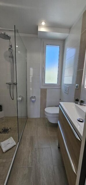 A modern bathroom with a glass-enclosed shower, a toilet, and a sink. - Cannes Sea View Beach Private Room (Cannes)