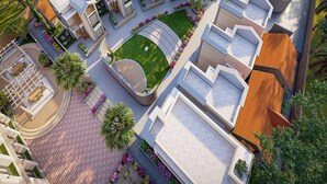 Un moderno complejo hotelero con varias edificaciones, una piscina y jardines ajardinados.