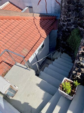 Eine Treppe führt zu einem Gebäude mit roten Ziegeldach.