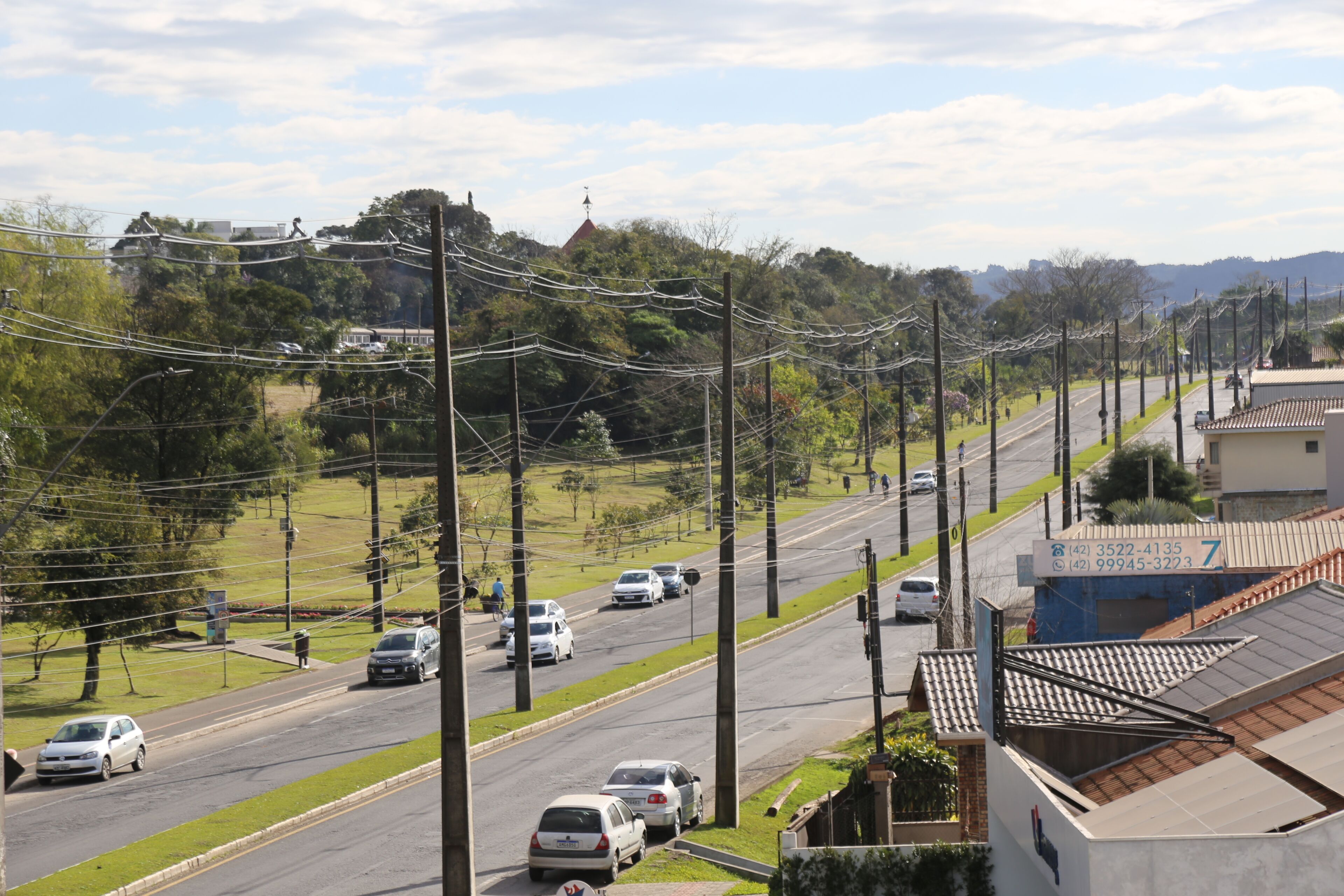 Vista de la calle con coches, cables eléctricos y edificios.