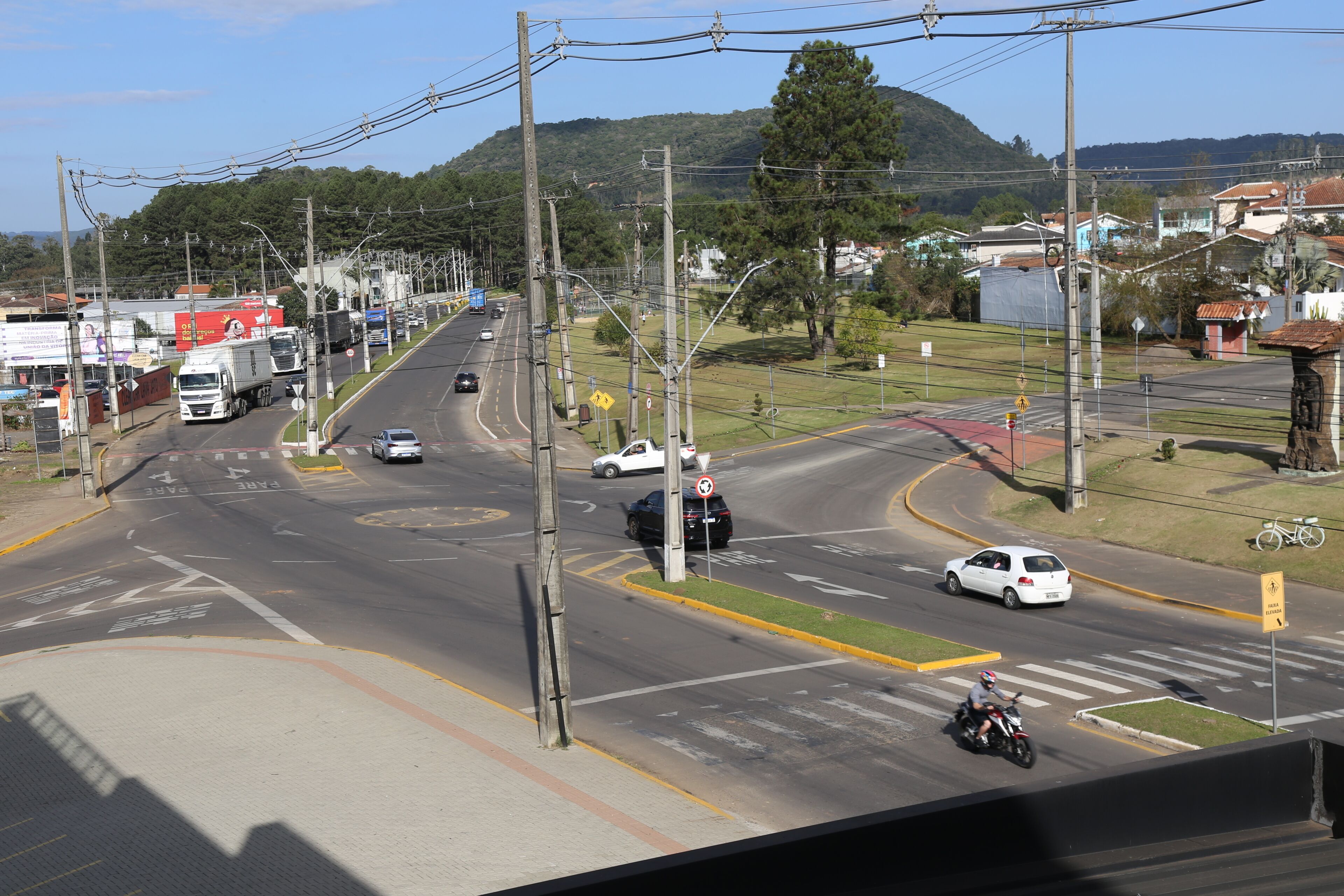 A multi-lane road with vehicles, a pedestrian crossing, and a cyclist.
