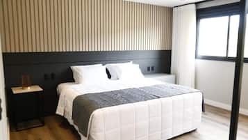 Un dormitorio moderno con cama, mesitas de noche y una ventana con cortinas.
