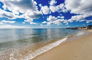 Una playa con cielos despejados y olas.