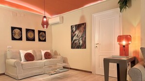 Uma sala de estar com sofá, mesa de centro e abajur.